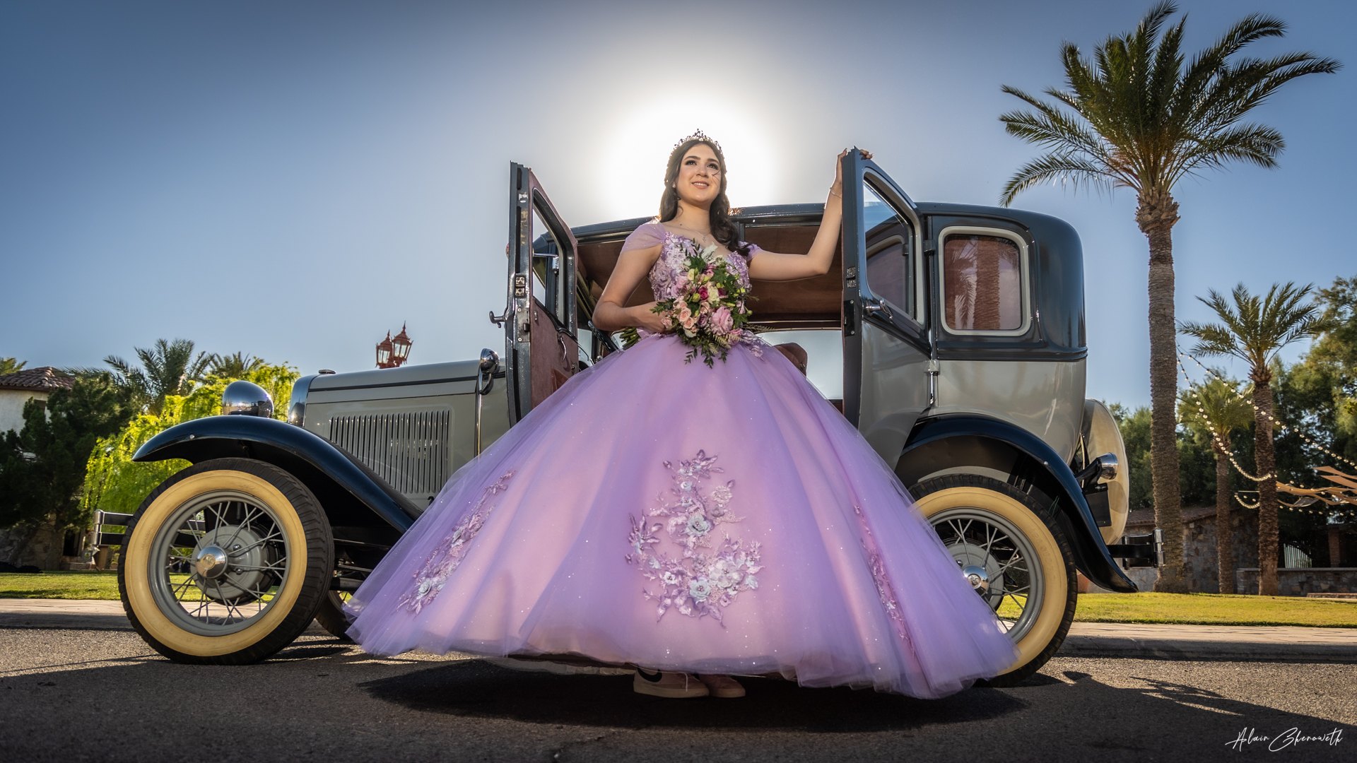 Quinceañera con vestido lila frente a una fuente
